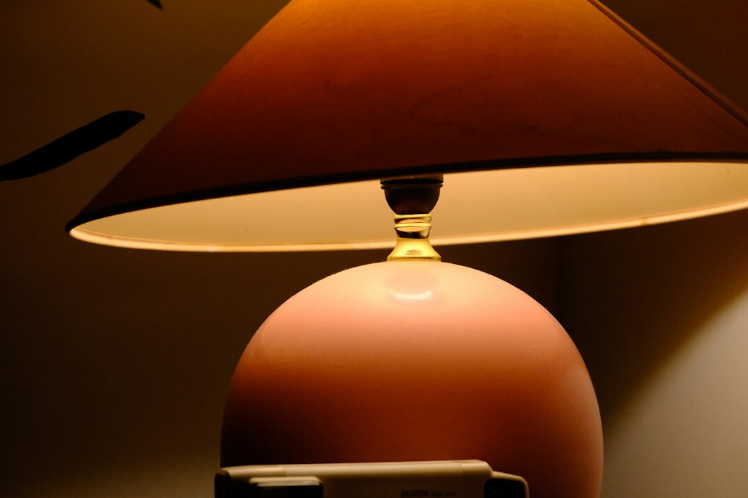 Documents and pen lying on a desk under a lamp